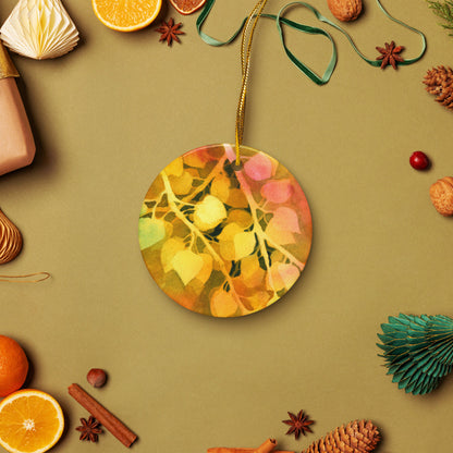 Golden Aspen ceramic ornament on a gold string among holiday oranges, pinecones and star anise