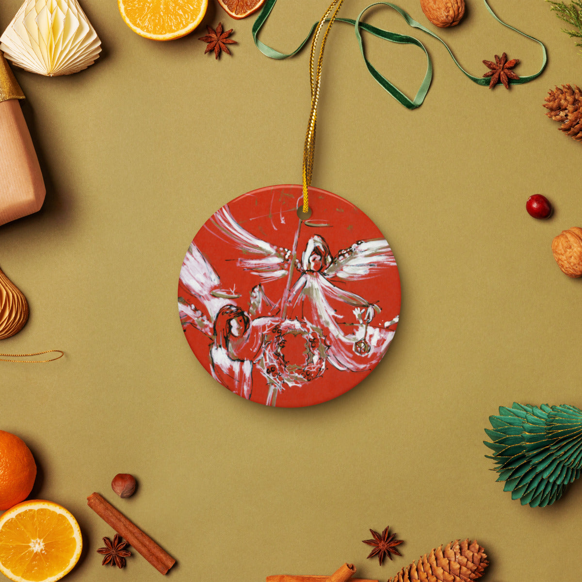 Christmas Angels ceramic ornament on a gold string among holiday oranges and pinecones