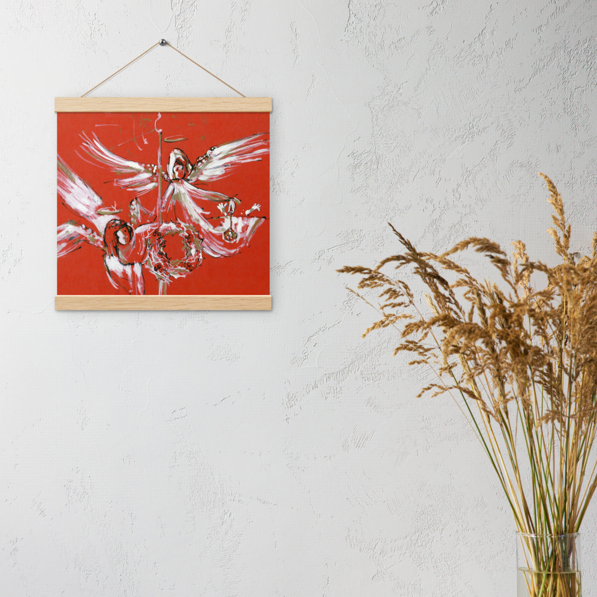 Christmas Angels hanging poster on a light wall beside dried grasses