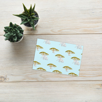 Elephant and Trees greeting card on a wooden table beside small succulents