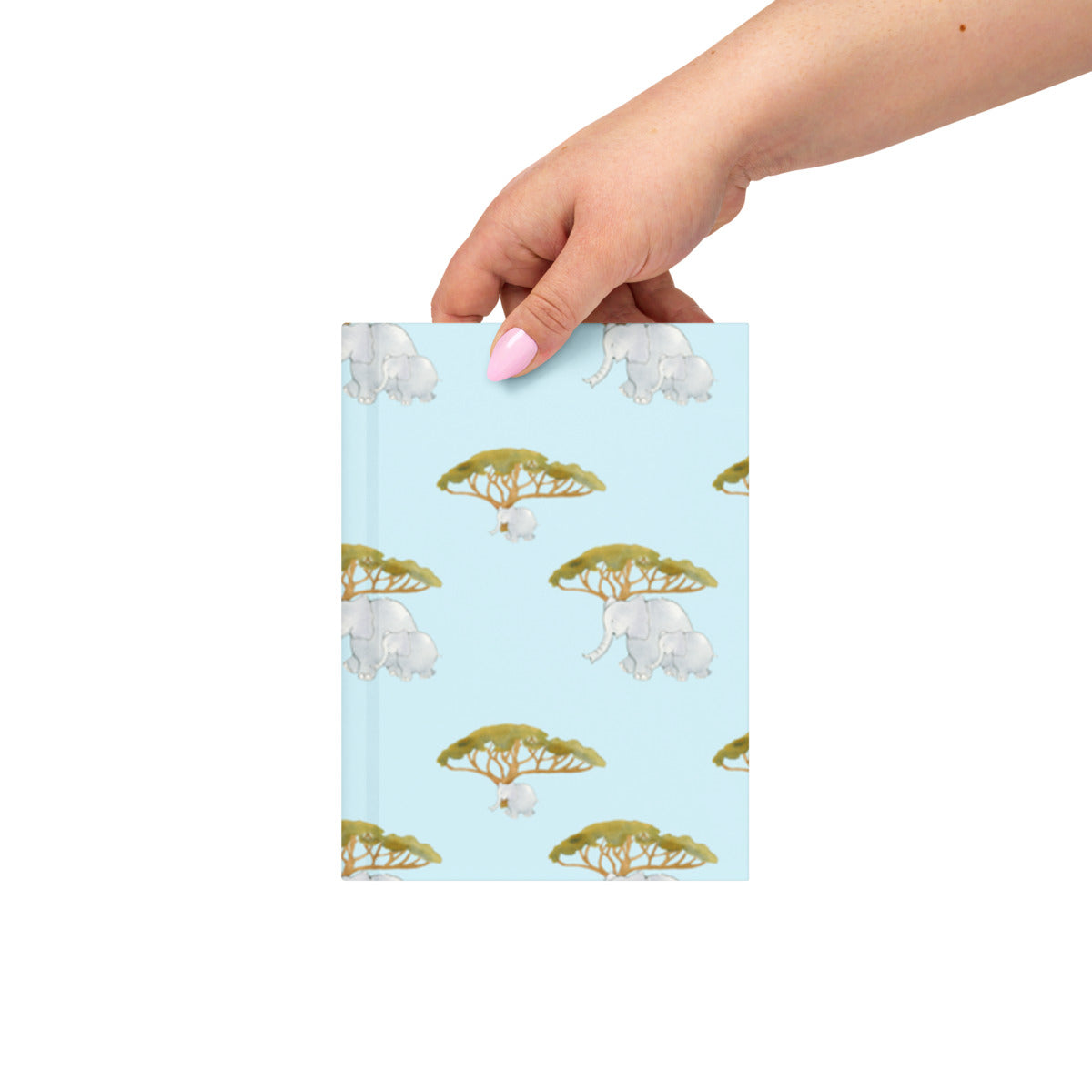 Hand holding the Elephant and Trees hardcover journal